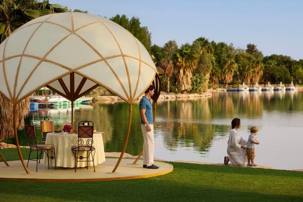 een vrouw op een podium naast een meer bij Nofa Riyadh, A Radisson Collection Resort in Ţibrāk