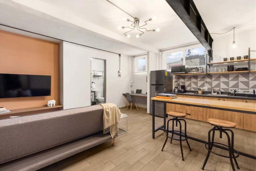 a kitchen with a couch and a counter with stools at MS Luminosa Suite Arcos Hercules HD2 in Laborcillas