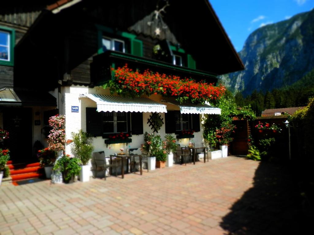 a building with flowers on the side of it at Landhaus Osborne in Obertraun