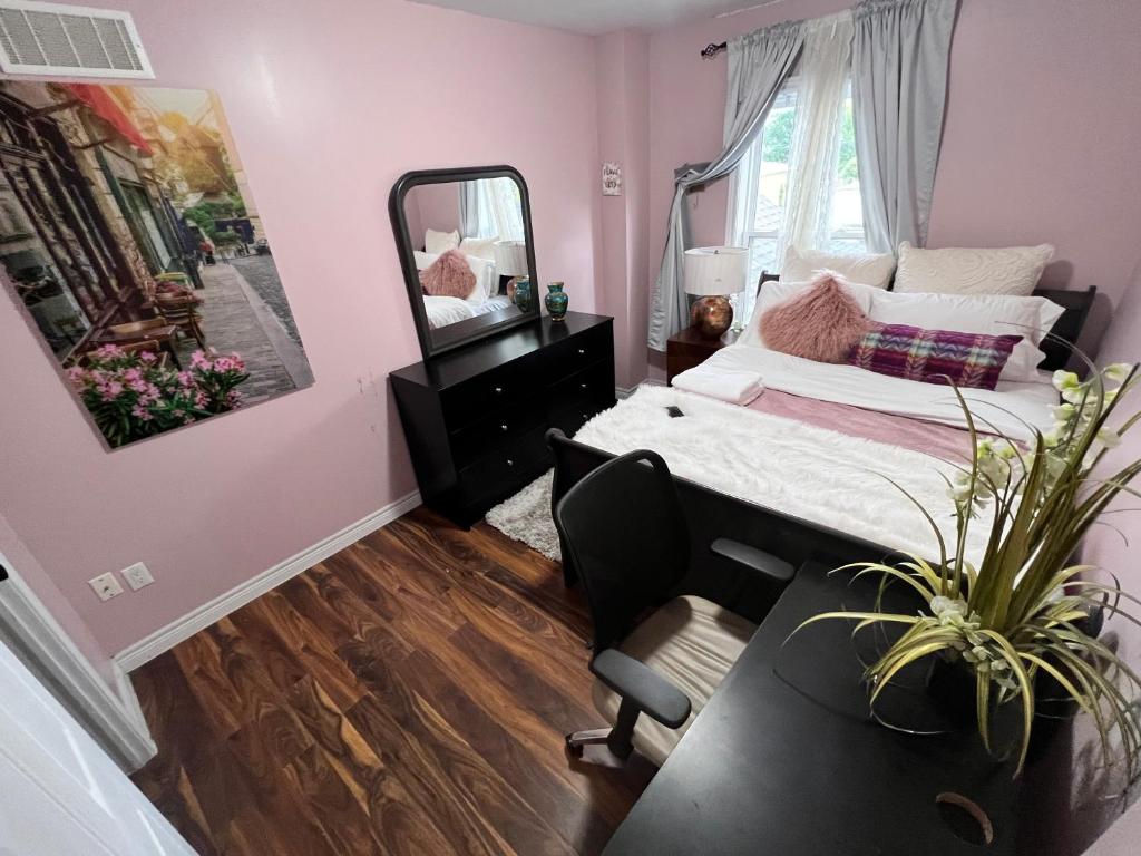 a bedroom with a bed and a mirror and a chair at Charming Victorian Home very close to Hamilton General Hospital in Hamilton