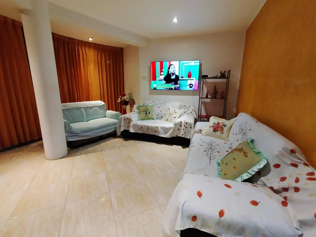 sala de estar con sofá y TV en Apartamento en el corazón de Trujillo, en Trujillo