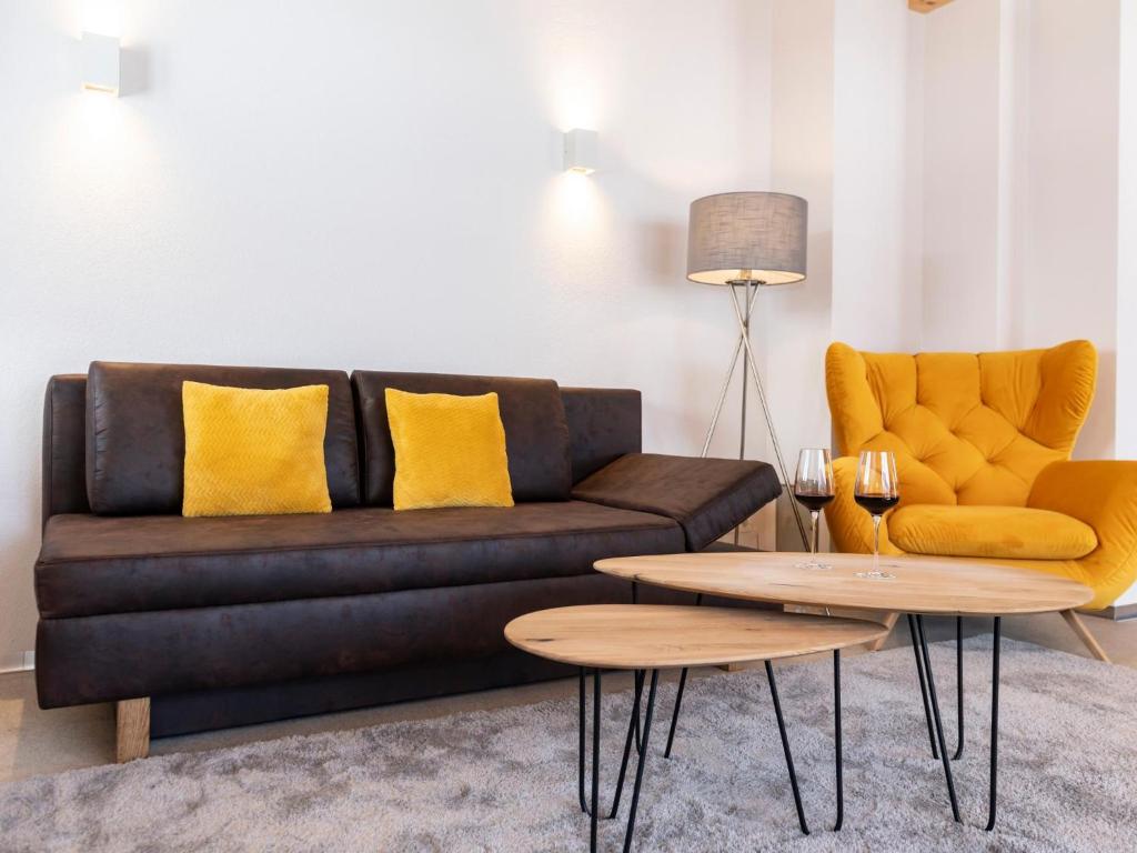 - un salon avec un canapé noir et des oreillers jaunes dans l'établissement Tirolee Marchegg, à Wildschönau