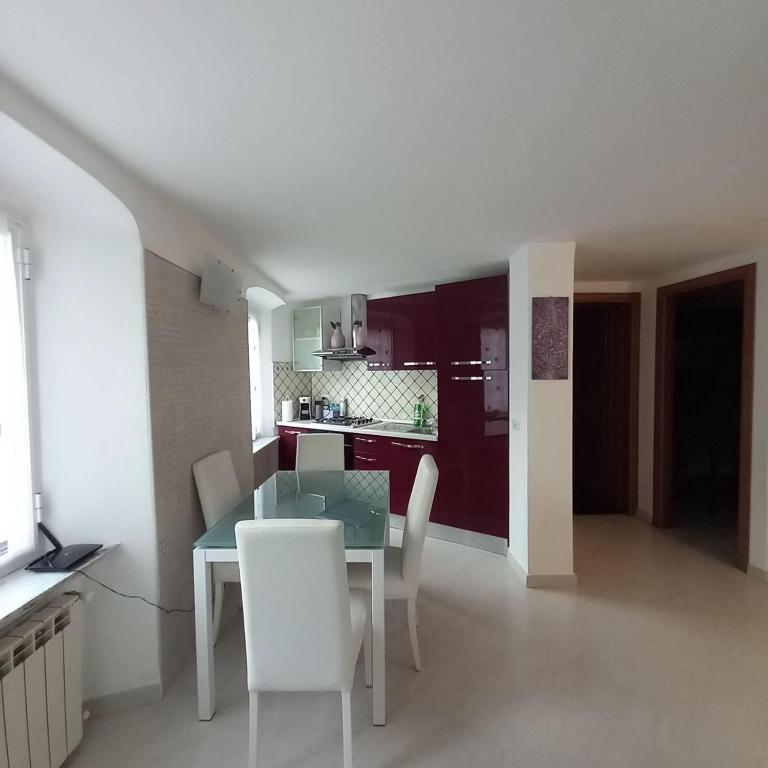 a kitchen and dining room with a table and chairs at Casa Caia in Genoa