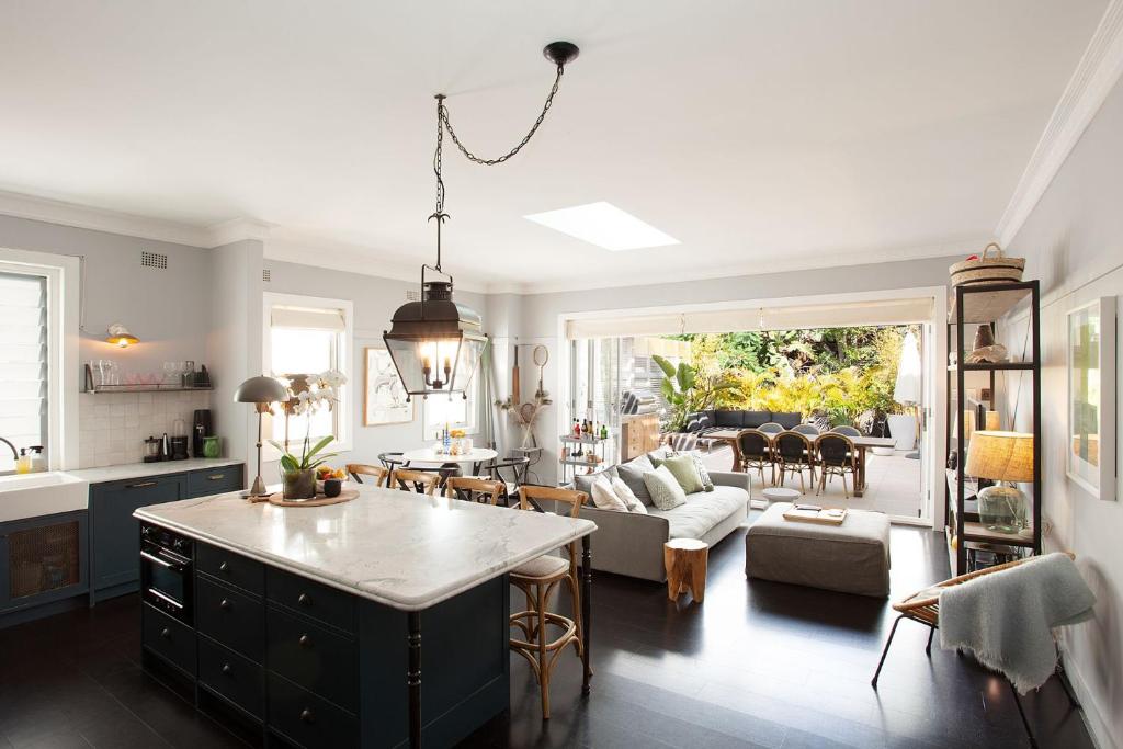 Modern Muse, Bellevue Hill في سيدني: مطبخ وغرفة معيشة مع أريكة وطاولة