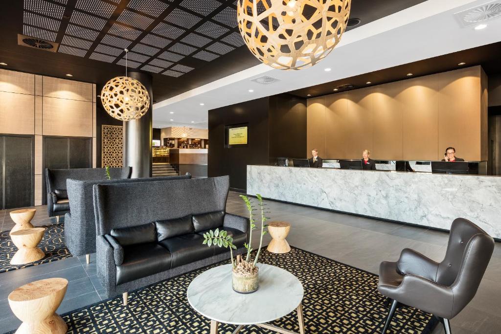 a lobby of a hotel with chairs and a counter at Hotel Grand Chancellor Brisbane in Brisbane