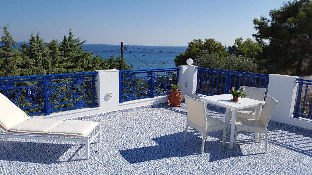un patio con 2 sillas y una mesa en el balcón en Mediterraneo Apartments, en Archangelos