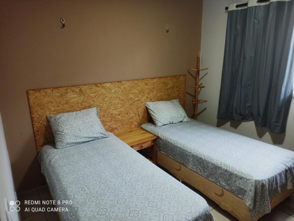 een slaapkamer met 2 bedden en een raam bij Casa PHB in Parnaíba