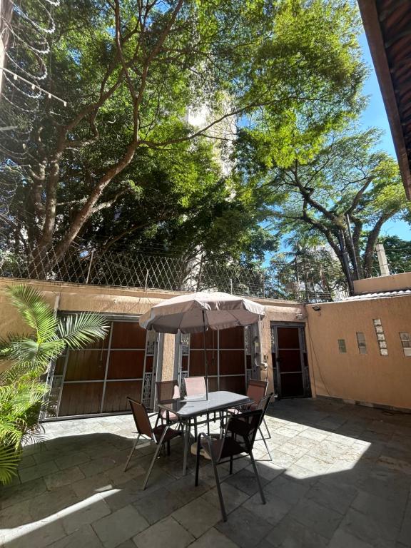 a table and chairs with an umbrella on a patio at Coliving Brooklin e Chácara Santo Antonio in Sao Paulo