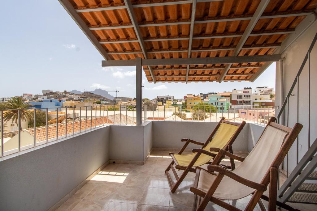 2 sillas en un balcón con vistas a la ciudad en Maya Apartments, en Mindelo