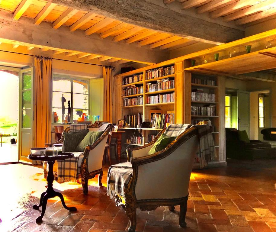 Dimora Buonriposo Pienza Country House في Contignano: مكتبة بها كراسي وطاولة وأرفف كتب