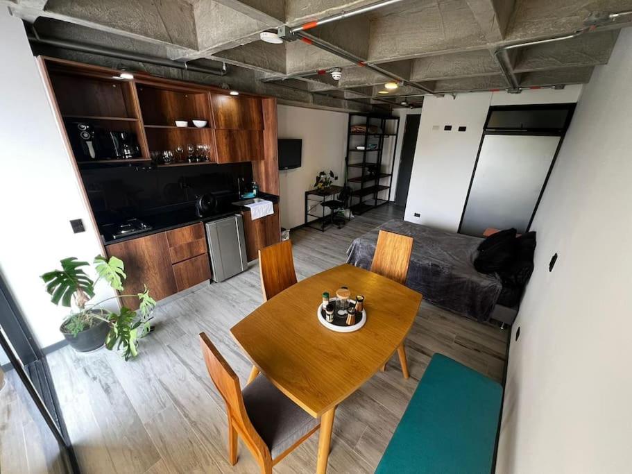 a living room with a table and a kitchen at Cercano al Aeropuerto y nuevo in Pereira