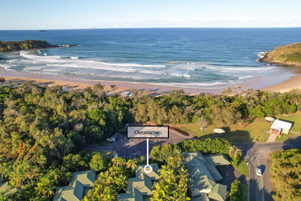 an overhead view of a beach with a sign at Oceanique in Coffs Harbour