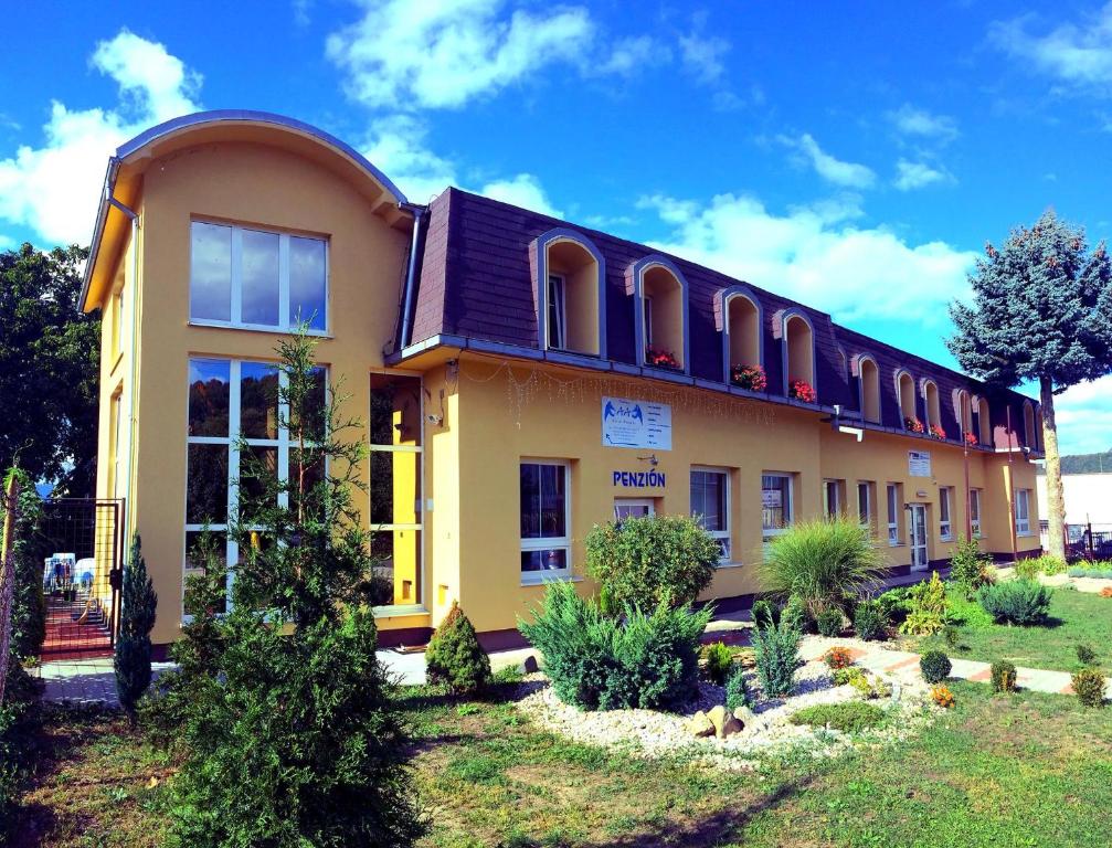 een geel gebouw met veel ramen bij Pension Avio Angels in Žiar nad Hronom
