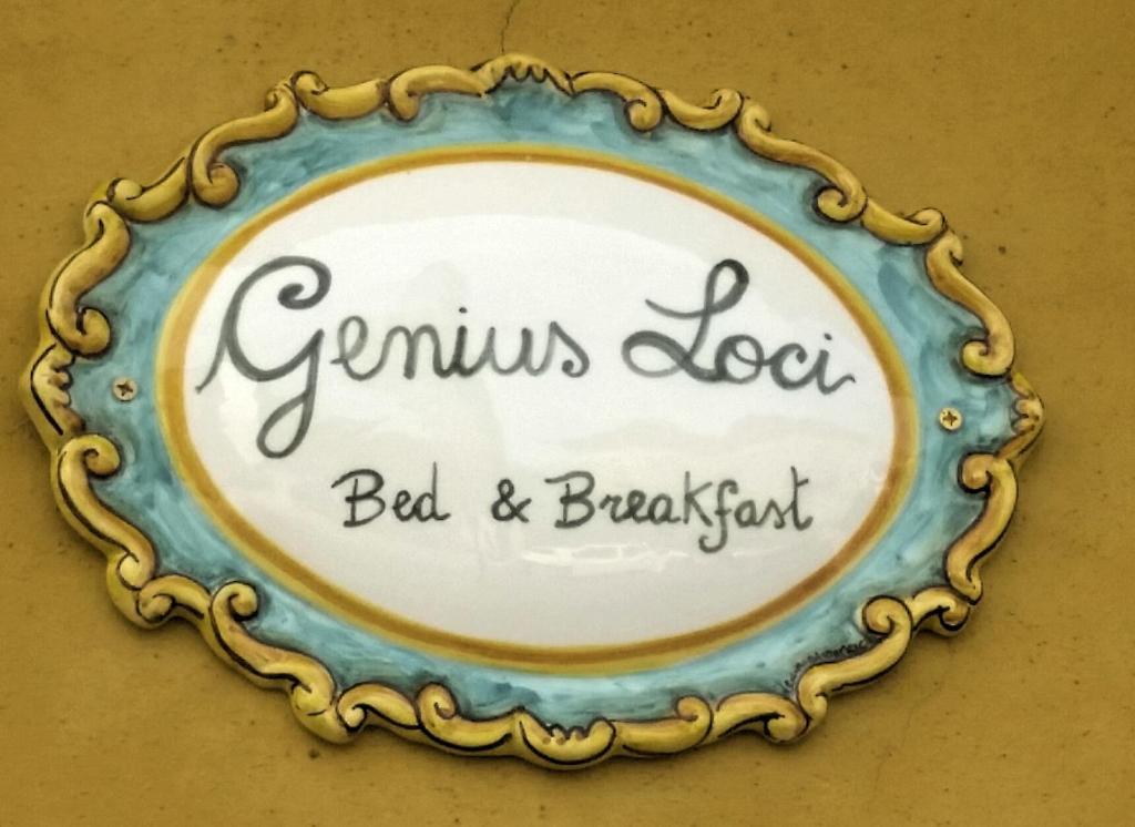 um prato com um cartaz que diz gimulus loot cama e pequeno-almoço em Genius Loci em Caserta