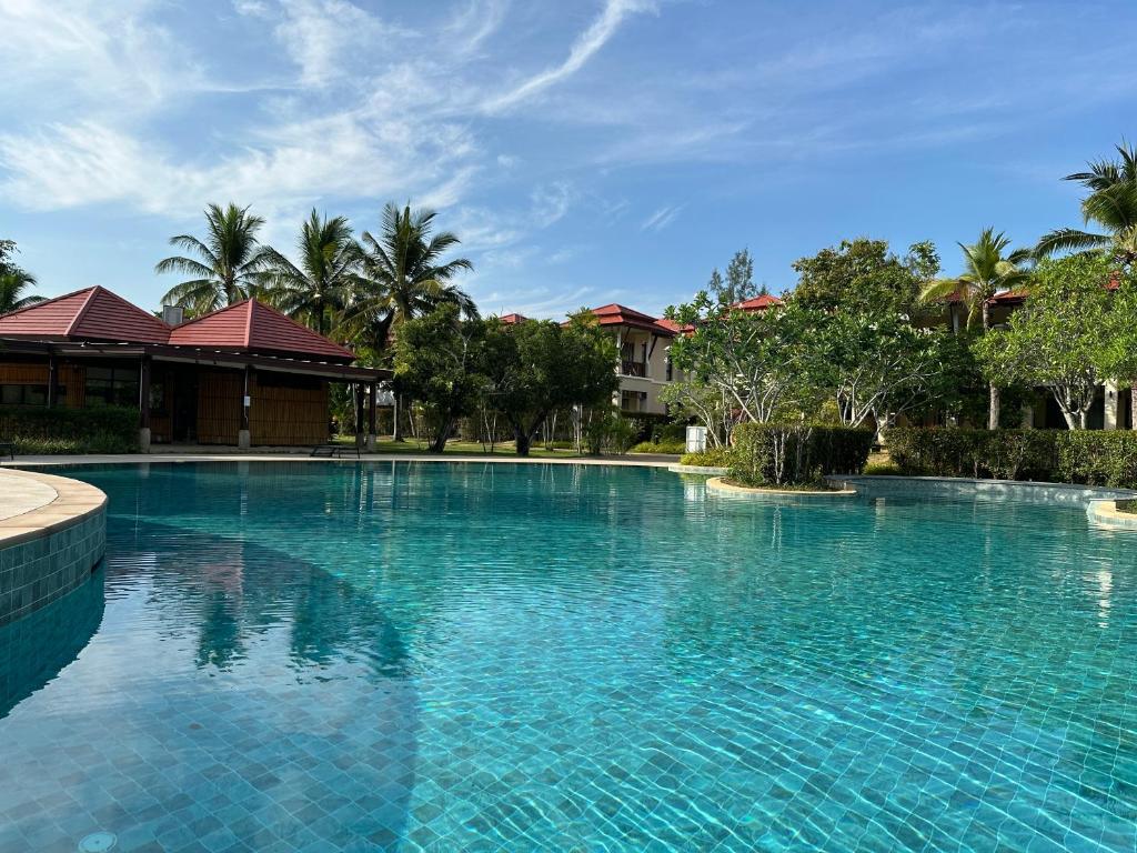 a large swimming pool with blue water at Phuket Laguna Beach - Big Family Pool Villa 2 Extra Large bedrooms in Layan Beach