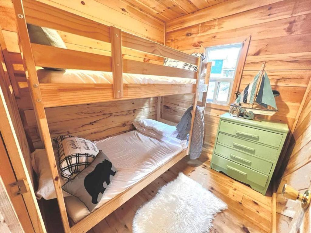 Muskoka Escape في ميناء كارلينج: غرفة نوم مع أسرة بطابقين في كابينة خشبية
