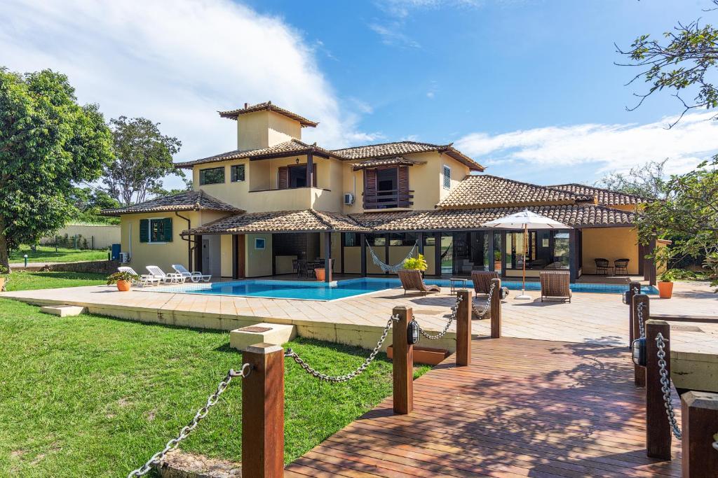 a villa with a swimming pool and a house at Casa Sol Búzios in Armacao dos Buzios
