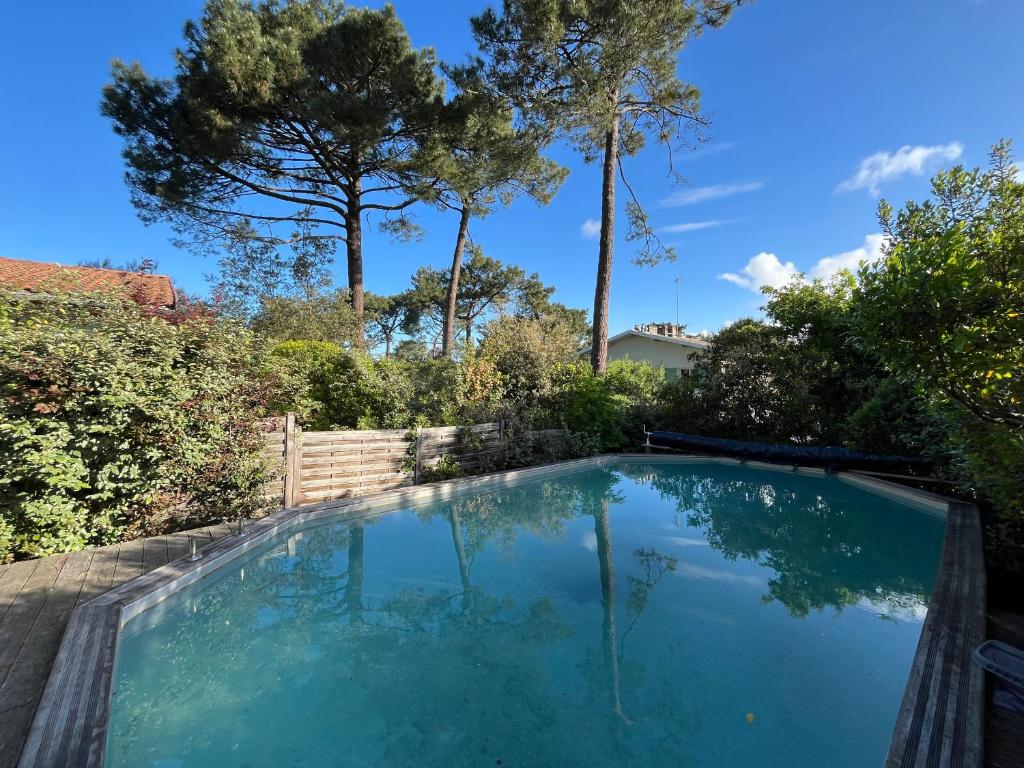 una piscina en un patio con árboles en Maison Pyla-sur-Mer, 4 pièces, 6 personnes - FR-1-319-541, en La Teste-de-Buch