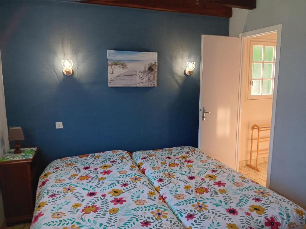 sypialnia z łóżkiem z kwiatową kołdrą w obiekcie Maison spacieuse avec jardin, proche commerces et plage, 6 couchages, parking privatif - FR-1-239-902 w mieście Capbreton