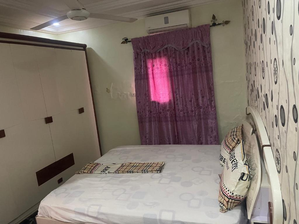Kleines Zimmer mit einem Bett und einem Fenster in der Unterkunft RÉSIDENCE ACHIKA INELIA in Bobo-Dioulasso