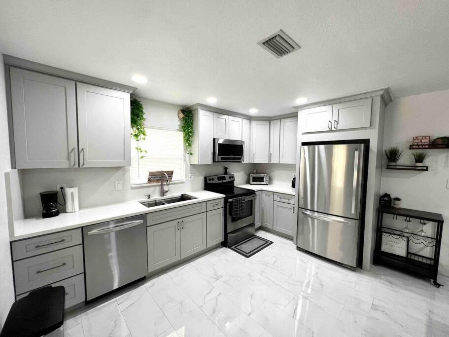 a kitchen with white cabinets and stainless steel appliances at Modern cozy with pool and big backyard in Tampa