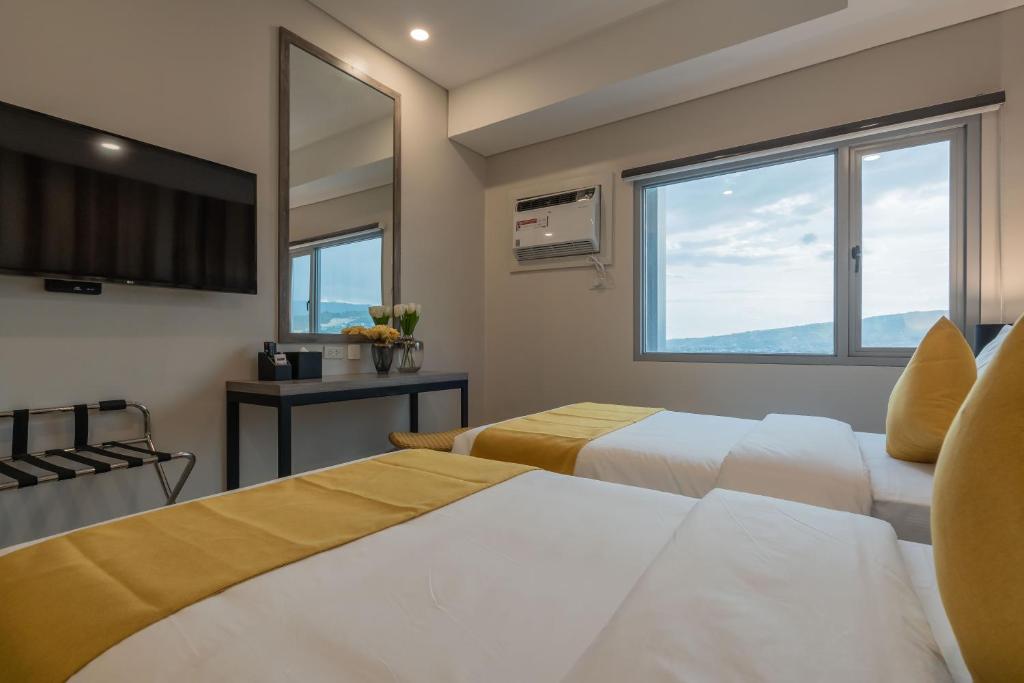 um quarto de hotel com duas camas e uma televisão em Bayfront Hotel Cebu Capitol Site em Cebu