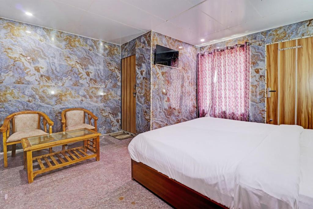 a bedroom with a bed and a table and chairs at OYO Hotel Neilkanth in Dhanaulti