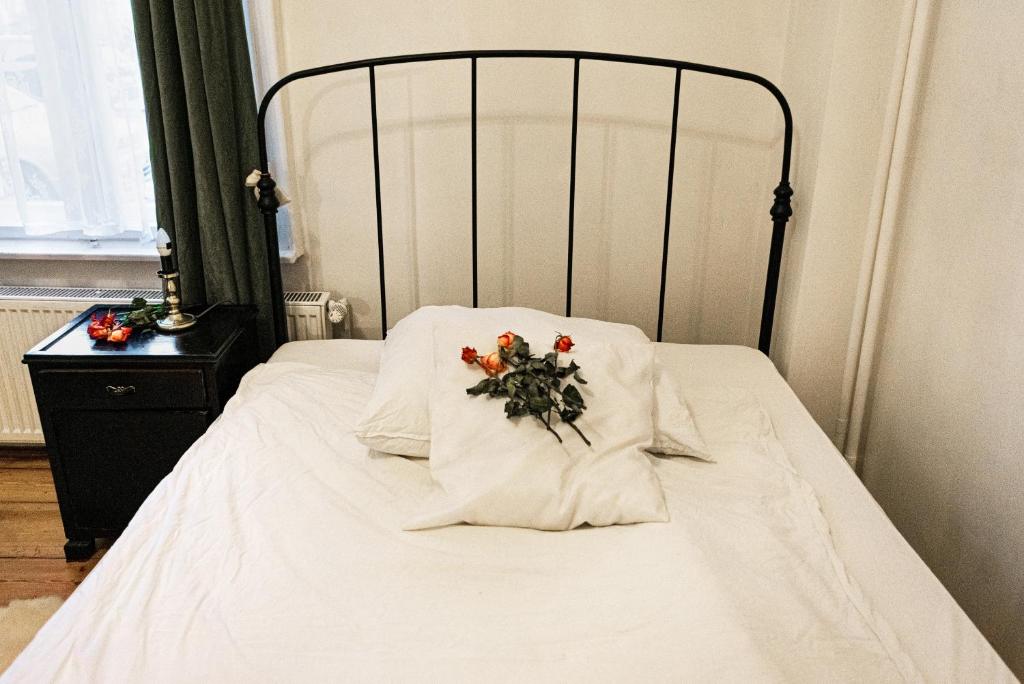 a white bed with a flower arrangement on it at Artistic Altbau Apartment in Berlin