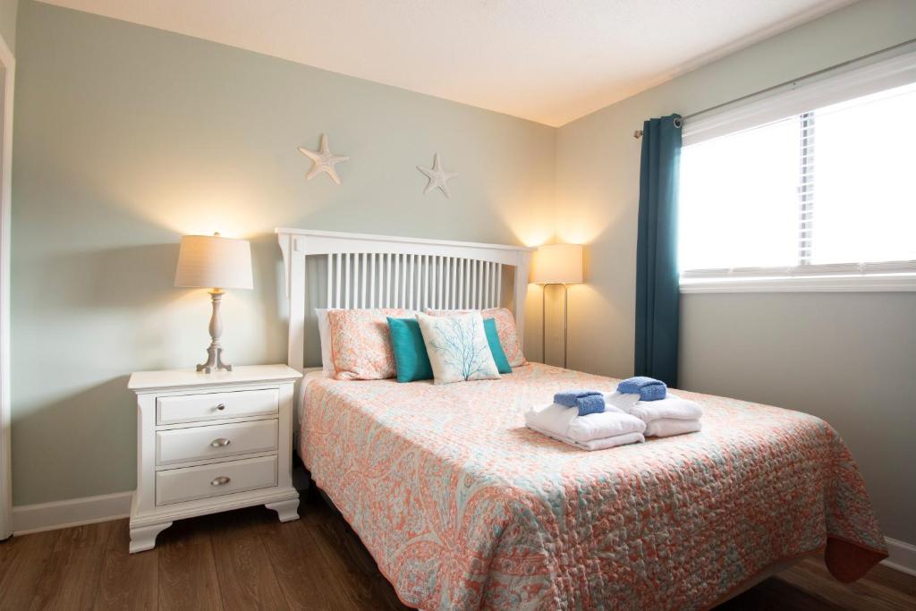 1 dormitorio con 1 cama con 2 toallas en Family Getaway - Boardwalk to the Beach, 3 pools, Tennis, en Hilton Head Island