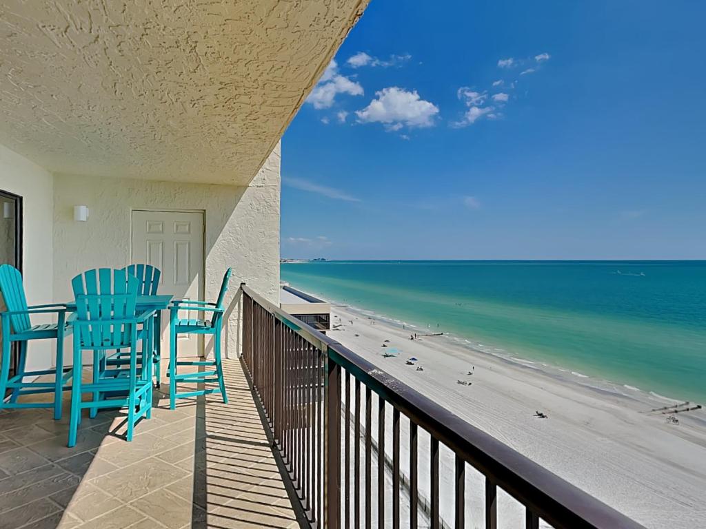 a balcony with two blue chairs and the beach at Ocean Sands 1002 in St Pete Beach