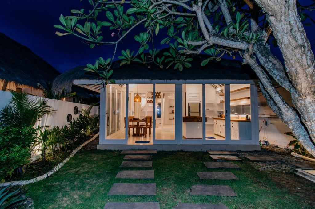 une petite maison avec un arbre dans la cour la nuit dans l'établissement Villa Cinta Lembongan, à Nusa Lembongan
