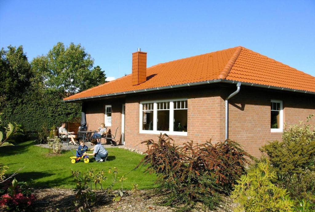 una casa de ladrillo con dos niños jugando en el patio en Ferienhaus Hopp en Fehmarn