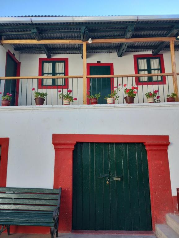 a green door and a bench in front of a building at Hospedaje Casa Primavera in Cotahuasi