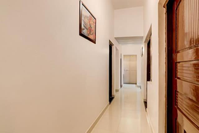 korytarz z białymi ścianami, białymi podłogami i drzwiami w obiekcie CASA INN w mieście Waranasi