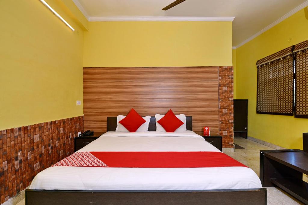 a bedroom with a large bed with red pillows at OYO Flagship Maira Residency in Dehradun