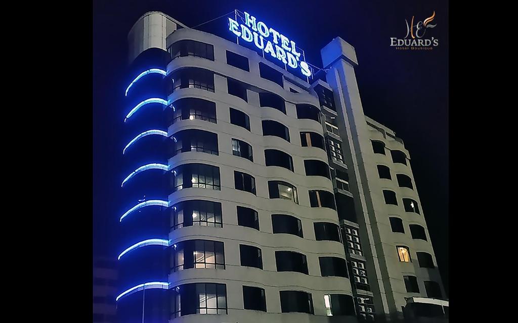 un edificio con una señal de luz azul en él en Hotel Eduards Suite, en Macuto