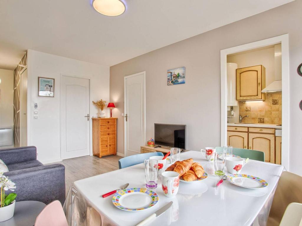 une table blanche avec une plaque de nourriture dans l'établissement Appartement cosy pour 4 à Cabourg avec balcon ensoleillé, à 400m de la plage - FR-1-788-6, à Cabourg