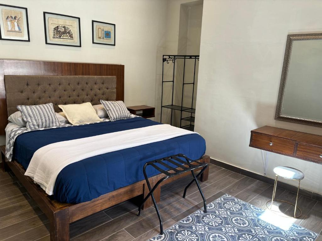 een slaapkamer met een groot bed en een televisie bij Hotel Boutique Casona los Pavorreales in Durango