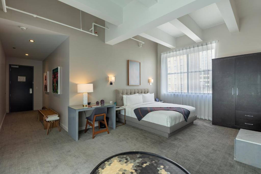 a hotel room with a bed and a desk and a window at Stanton House El Paso in El Paso