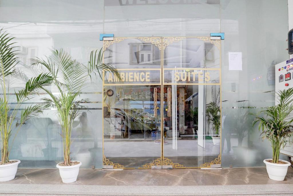 a store front with a golden door and palm trees at Hotel Ambience Dilli 37 At - Near IGI Airport in New Delhi