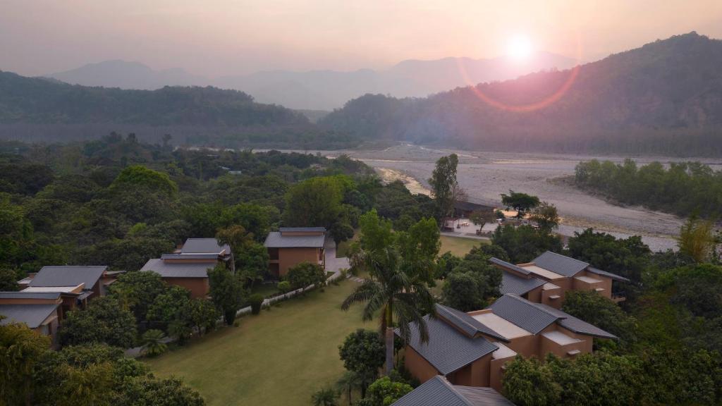 an aerial view of a resort with the sunset in the background at voco Jim Corbett, an IHG Hotel in Rāmnagar