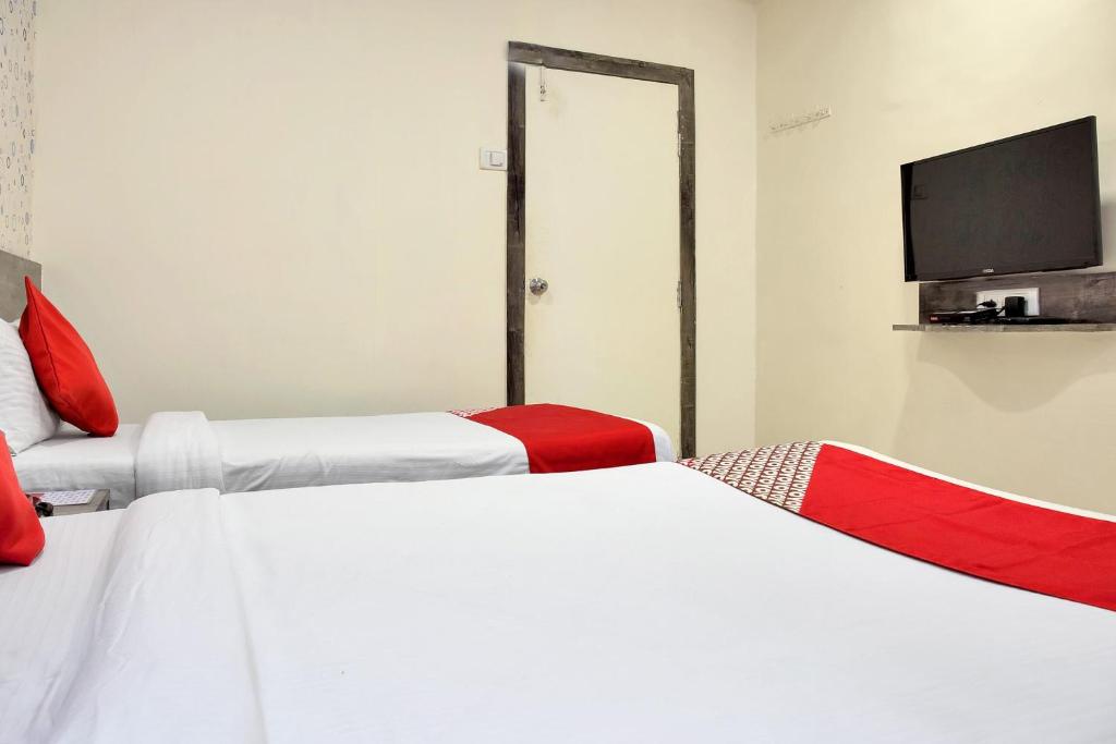 a room with two beds and a flat screen tv at OYO Rana Residency Near Western Express Highway Metro Station in Mumbai
