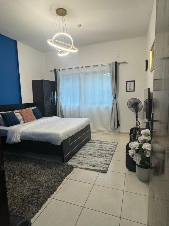 een slaapkamer met een bed en een raam bij Cozy Dala Room in Sharjah