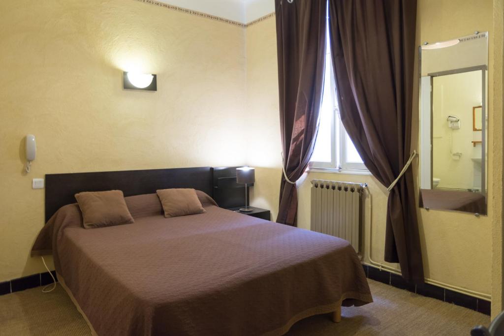 
A bed or beds in a room at Hôtel Jaures
