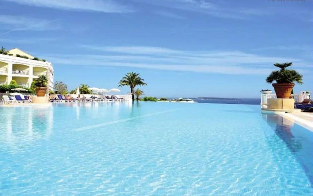 une grande piscine d'eau bleue en face d'un complexe dans l'établissement T2 clim-terrasse plein sud vue mer, à Cannes