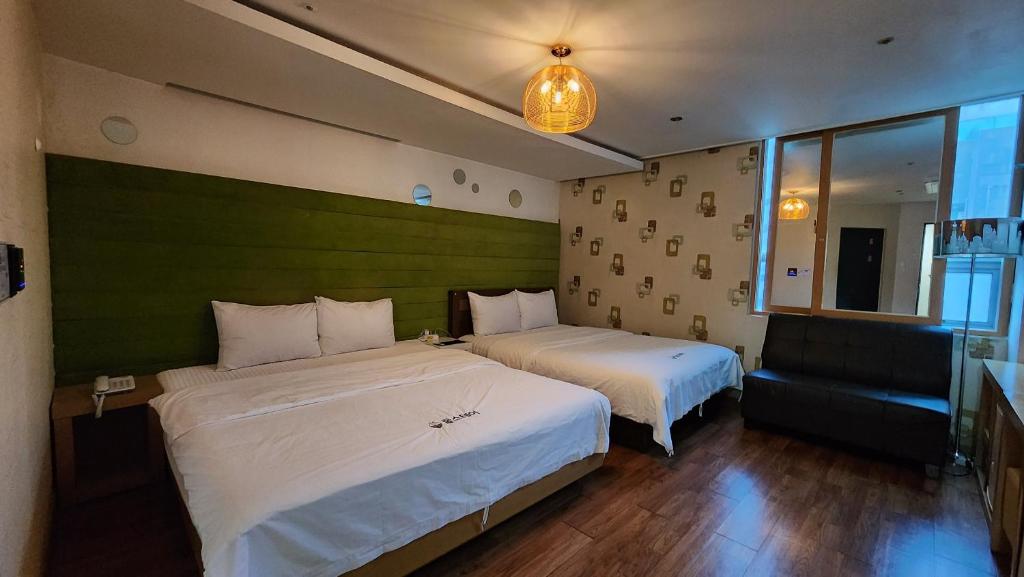 una camera d'albergo con due letti e un divano di Gimhae Business Hotel K a Gimhae