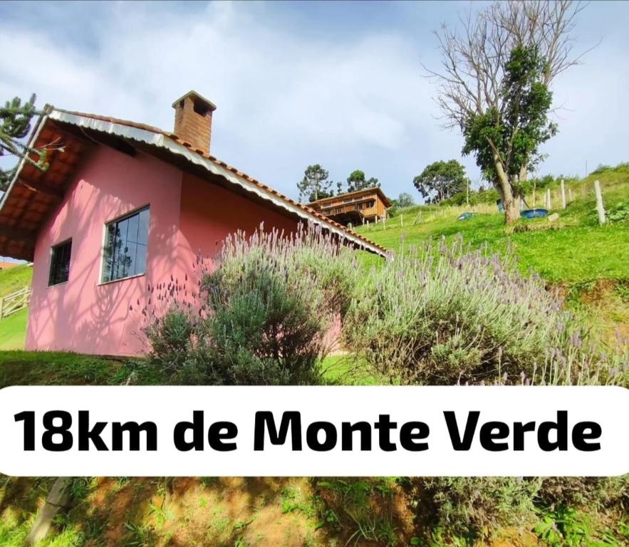 a pink house with the words kkm de montreillevenue at Chalé Sonho Diniz 1 in Monte Verde