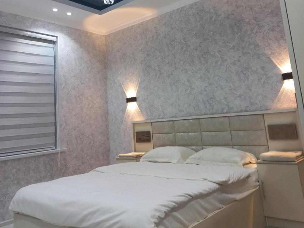 Un dormitorio con una cama grande y una ventana en Apart Khujand en Khujand