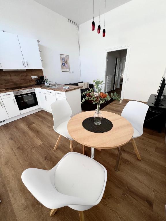 ファーレルにあるSuite One Langestr IIのキッチン(木製テーブル、白い椅子付)
