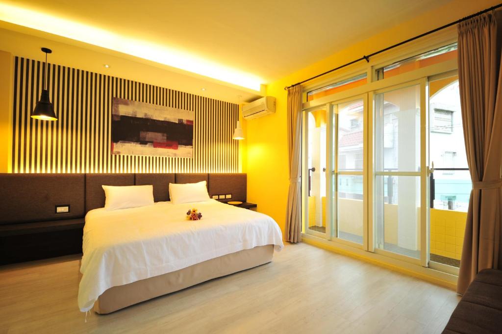 a bedroom with a white bed and a large window at Little Sunshine in Dongshan
